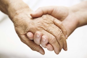 adult helping senior in hospital